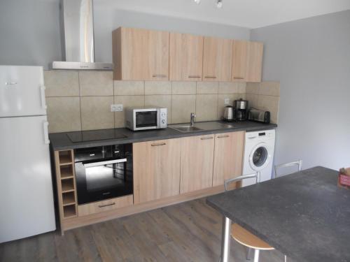 une cuisine avec un évier et un micro-ondes dans l'établissement Gîtes du Saut des Cuves, à Xonrupt-Longemer