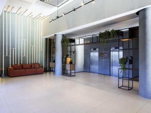 an office lobby with a couch and plants at ibis Botucatu in Botucatu