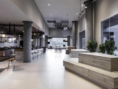 a lobby of a building with tables and chairs at ibis Botucatu in Botucatu