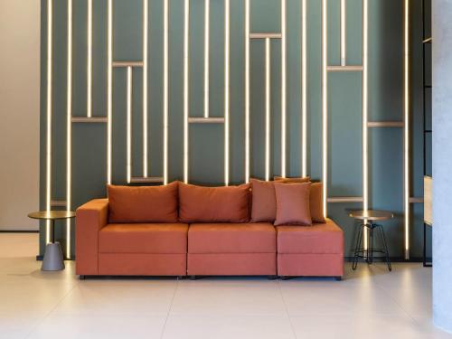 a orange couch sitting in a room with stripes at ibis Botucatu in Botucatu
