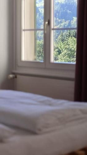 a bedroom with a bed and an open window at Krone Trogen in Trogen