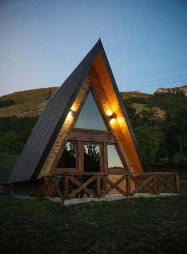 a small house with a triangular roof with lights on it at Etno house Nomad in Šavnik