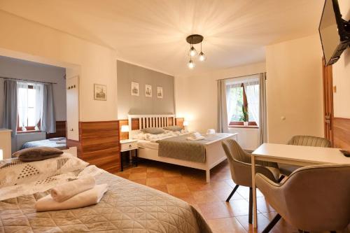 a bedroom with two beds and a table and chairs at Penzion U Horských in Čáslav