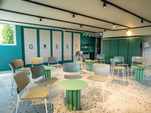 a room with tables and chairs in a room at Greet hôtel Montpellier Aéroport Parc des Expos in Mauguio
