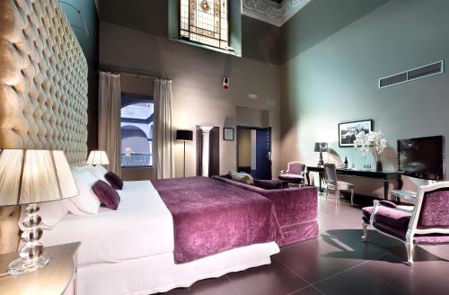 a bedroom with a large bed and a desk at Eurostars Sevilla Boutique in Seville
