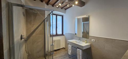 Un baño con ducha, lavabo y espejo. en Palazzo Poggini, en Anghiari