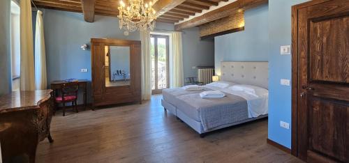 Un dormitorio con una cama, una mesa y un espejo. en Palazzo Poggini, en Anghiari