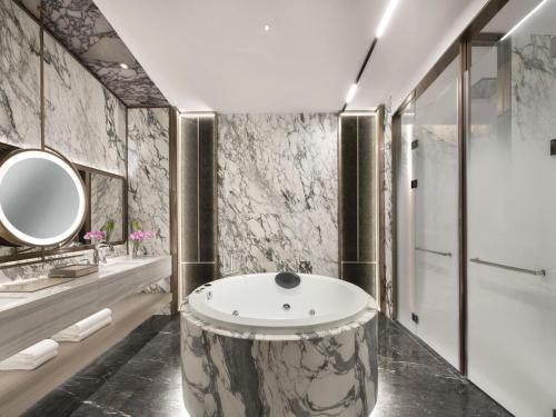 a bathroom with a tub and a sink at Pullman Shenzhen North in Shenzhen