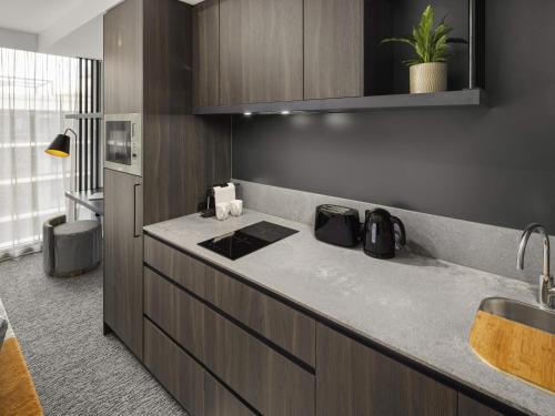 a kitchen with a counter top and a sink at The Sebel Canberra Campbell in Canberra