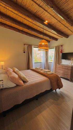 a bedroom with a large bed and a chandelier at Tulma Cabañas in Volcán