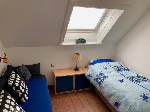 1 dormitorio con cama azul y tragaluz en Baumwipfelnest, en Seevetal