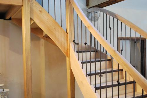 a wooden staircase with black railings at Gite Cap de la Hont in Laruns