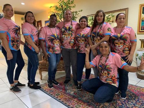 a group of people in pink shirts posing for a picture at Hotel Carnaval in La Ceiba