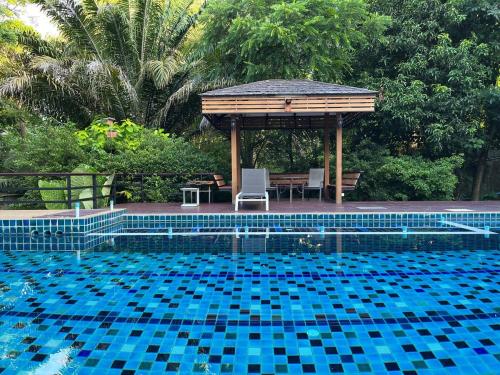 een zwembad met een prieel en een tafel en stoelen bij The Wild Villa Phuket Rawai in Nai Harn Beach