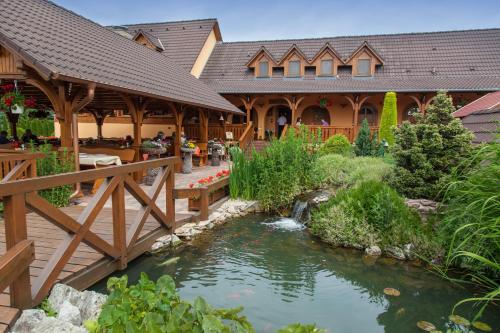 a house with a pond in front of a building at Csalánosi Vendégház in Kecskemét