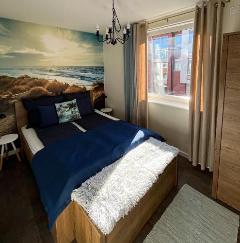 a bedroom with a bed with a painting on the wall at Baltic Crown - Premium Sea View Rewal in Rewal