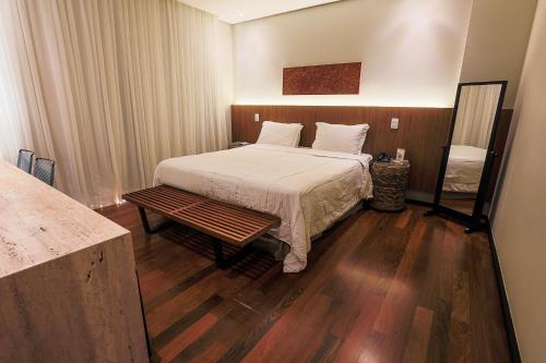 a bedroom with a bed and a wooden floor at Zank by Toque Hotel in Salvador