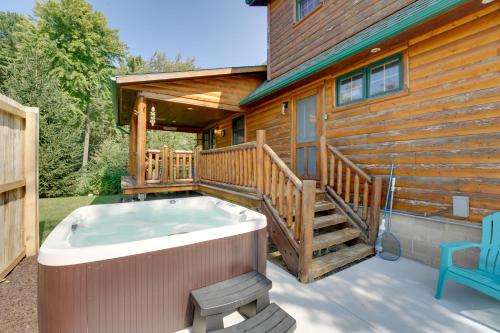 a hot tub on the deck of a log cabin at 1 Mi to Public Beach Port Austin Cabin with Hot Tub in Grind Stone City