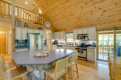 a large kitchen with a large island in a log cabin at 1 Mi to Public Beach Port Austin Cabin with Hot Tub in Grind Stone City