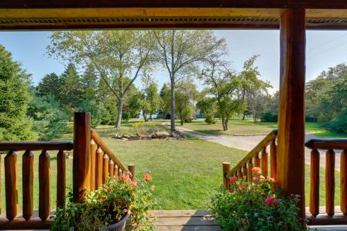a porch with flowers and a view of a park at 1 Mi to Public Beach Port Austin Cabin with Hot Tub in Grind Stone City