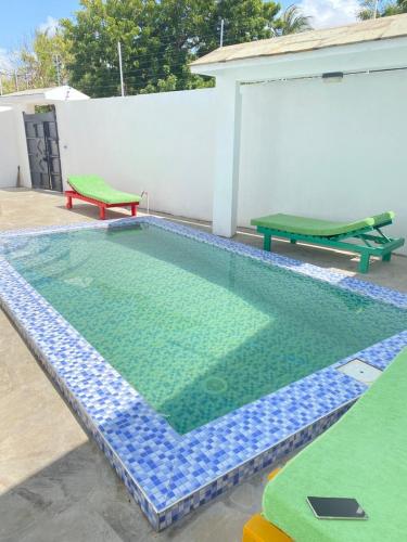 a small swimming pool in a backyard with a table at Banana House in Watamu