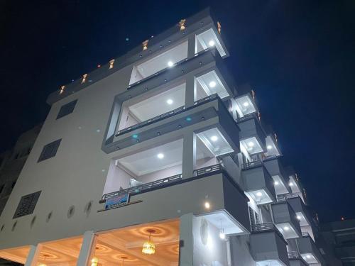 a tall white building with lights on it at Nguem's Appart in Odza I