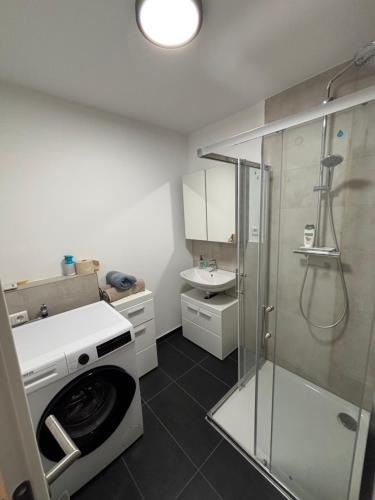 a bathroom with a shower and a washing machine at Erics Gästehaus in Uetersen