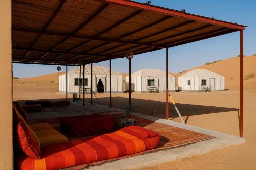 a bed under a tent in the desert at Bivouac Luna in Mhamid