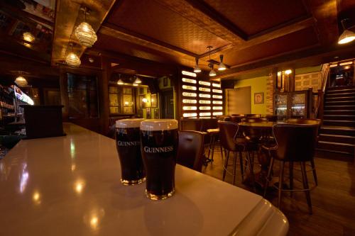 two glasses of beer sitting on a table in a restaurant at Wellington Temple Bar in Dublin