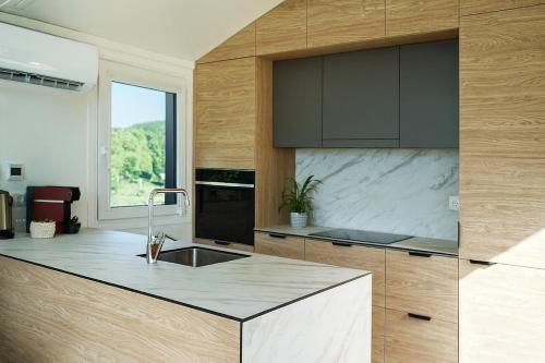 a kitchen with a sink and a counter top at Familienfreundliches Designer Ferienhaus im Grünen an der Grenze zu Österreich I 5 Personen in Untergriesbach