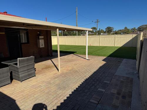 a pavilion with a bench on a brick patio at Modern Stylish House in Craigie in Perth