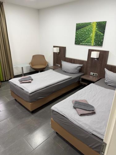 プルハイムにあるZehnthof2a WH02 OG - Apartment 2 SZ, 4 Bettenのベッド2台と椅子が備わる客室です。