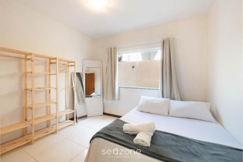 ein Schlafzimmer mit einem Bett und einem Fenster in der Unterkunft Apto c/ varanda e churrasq. a 400m do mar RBR0003 in Salvador
