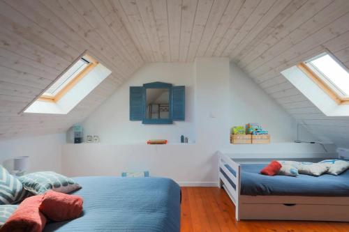 a bedroom with two beds in a attic with skylights at Charmante maison à Pleubian in Pleubian