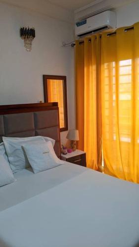 a bedroom with a bed and a window with yellow curtains at Dortmund Appartement in Bassa