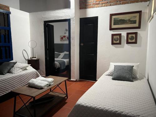 モンポスにあるApartamento Colonial Puerta Azulのベッド2台とテーブルと鏡のある部屋