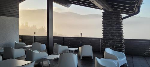 a restaurant with white chairs and a large window at BayVista, die Bayerwald Lodge in Lam