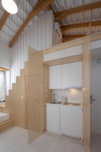 a kitchen with white cabinets and a staircase at L Anima in Skiathos