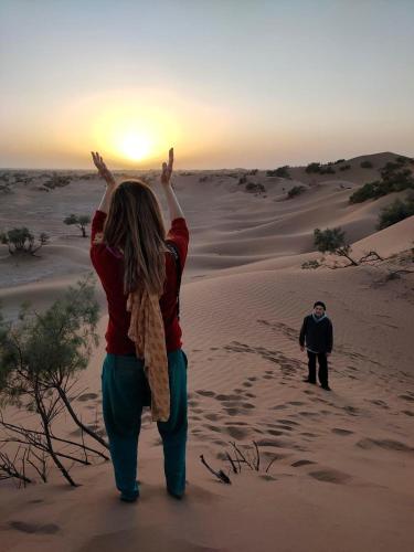 a man and a woman walking in the desert at Bivouac Luna in Mhamid