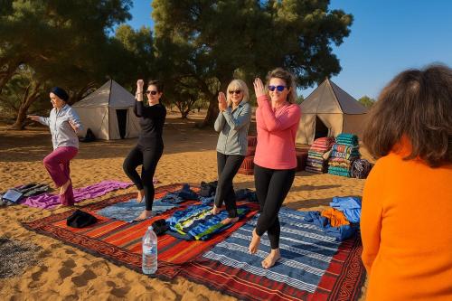 a group of women doing yoga on the beach at Bivouac Luna in Mhamid