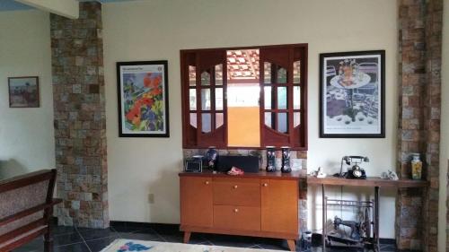 a room with a wooden cabinet and pictures on the wall at 4 bed rooms Country House- Giu Camacho in Batelão