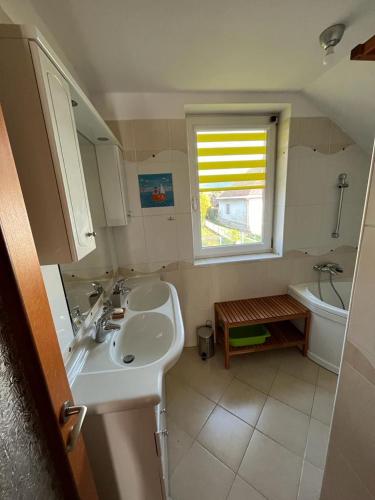 a bathroom with a sink and a toilet and a window at Machy Liptov in Liptovská Kokava