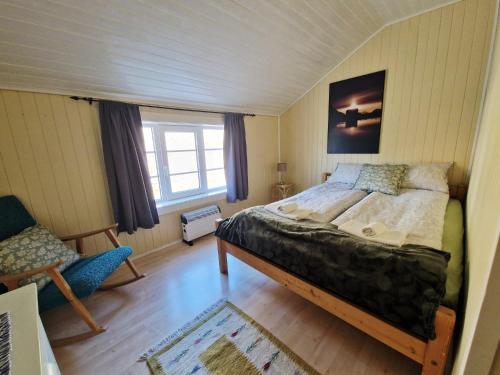 Un dormitorio con una cama grande y una ventana. en Arthur Brygga Nyksund, en Nyksund
