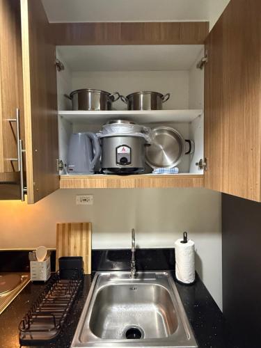 a kitchen with a sink and pots and pans at Obetskie's Haven Condotel in Manila