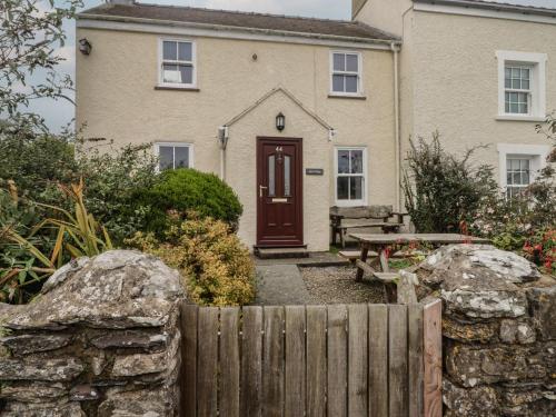 a house with a wooden fence in front of it at Garth Cottage in Haverfordwest