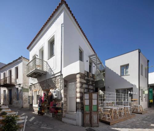 L Anima في مدينة سكياثوس: مبنى أبيض اللون به شرفة وطاولات على أحد الشوارع