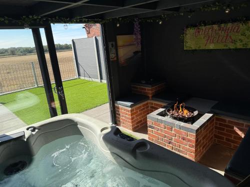 a hot tub with a fire pit in a backyard at California Fields 1 brand new open April 2025 in Scratby