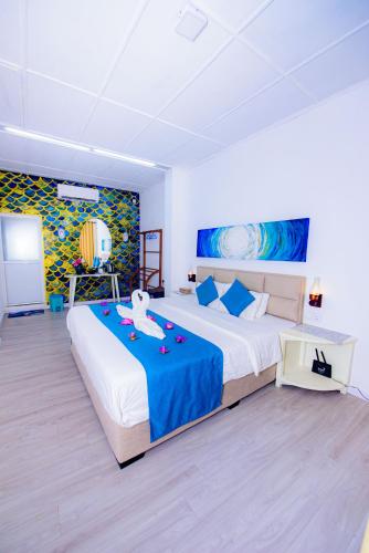 a large bedroom with a large bed with a blue blanket at Blue Maalu Resort in Ambalangoda