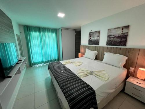 a bedroom with a large bed with a bow on it at Golf Ville Resorts Residence 3 Suítes, Porto das Dunas in Aquiraz