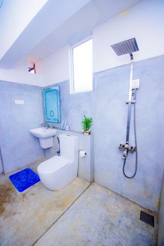 a bathroom with a toilet and a sink and a shower at Blue Maalu Resort in Ambalangoda